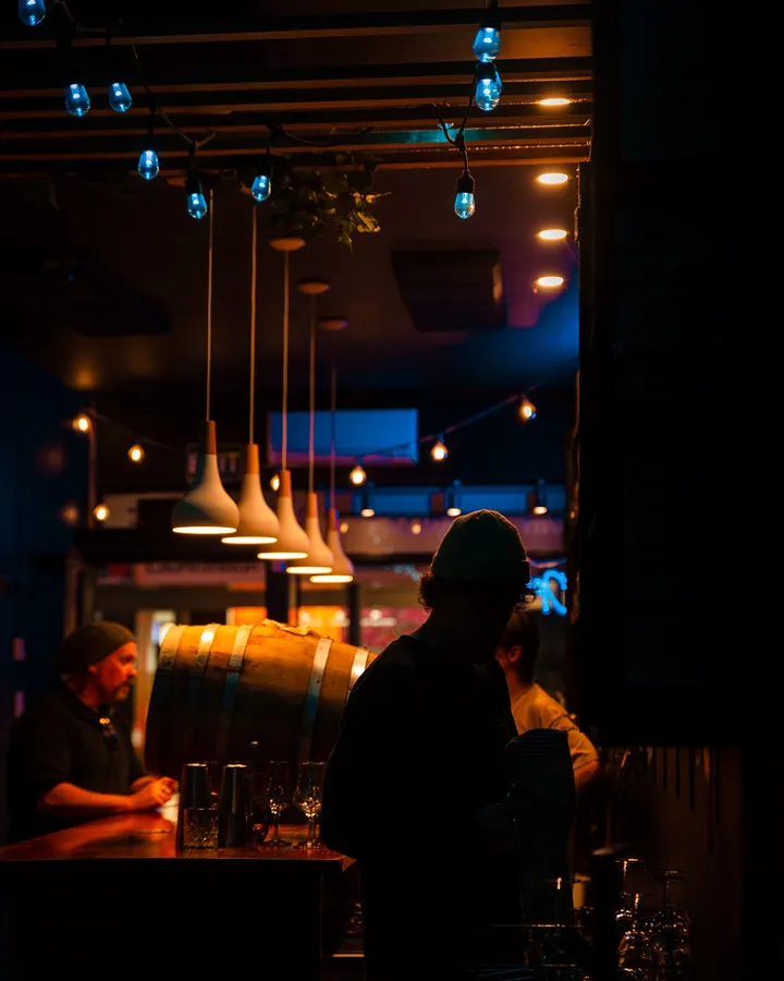 Pendant lamps hanging over the bar, a whisky barrel sitting on the back counter.