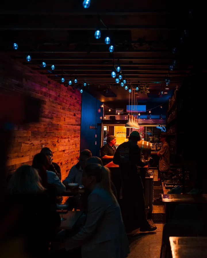 A full house on a weeknight, string lights strung down the ceiling and the brick wall lit warm.